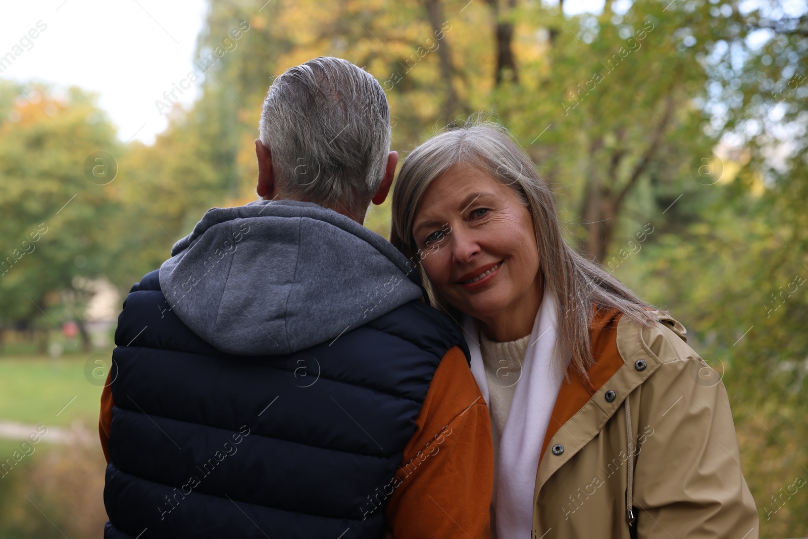 Photo of Portrait of affectionate senior couple in autumn park