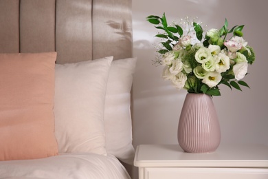 Photo of Bouquet of beautiful flowers on nightstand in bedroom, space for text. Interior design