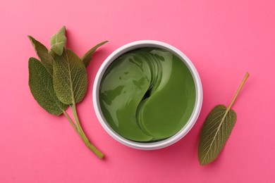 Photo of Jar of under eye patches and sage leaves on pink background, flat lay. Cosmetic product
