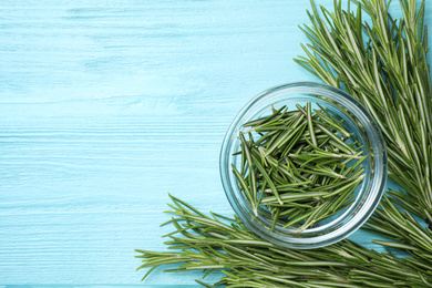 Photo of Green rosemary on light blue wooden table, top view with space for text. Healing herb