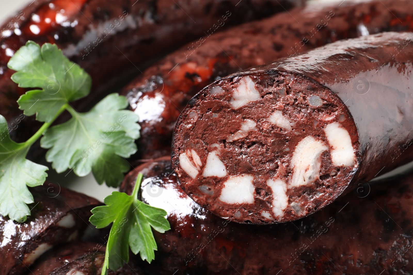 Photo of Cut tasty blood sausages with parsley, closeup