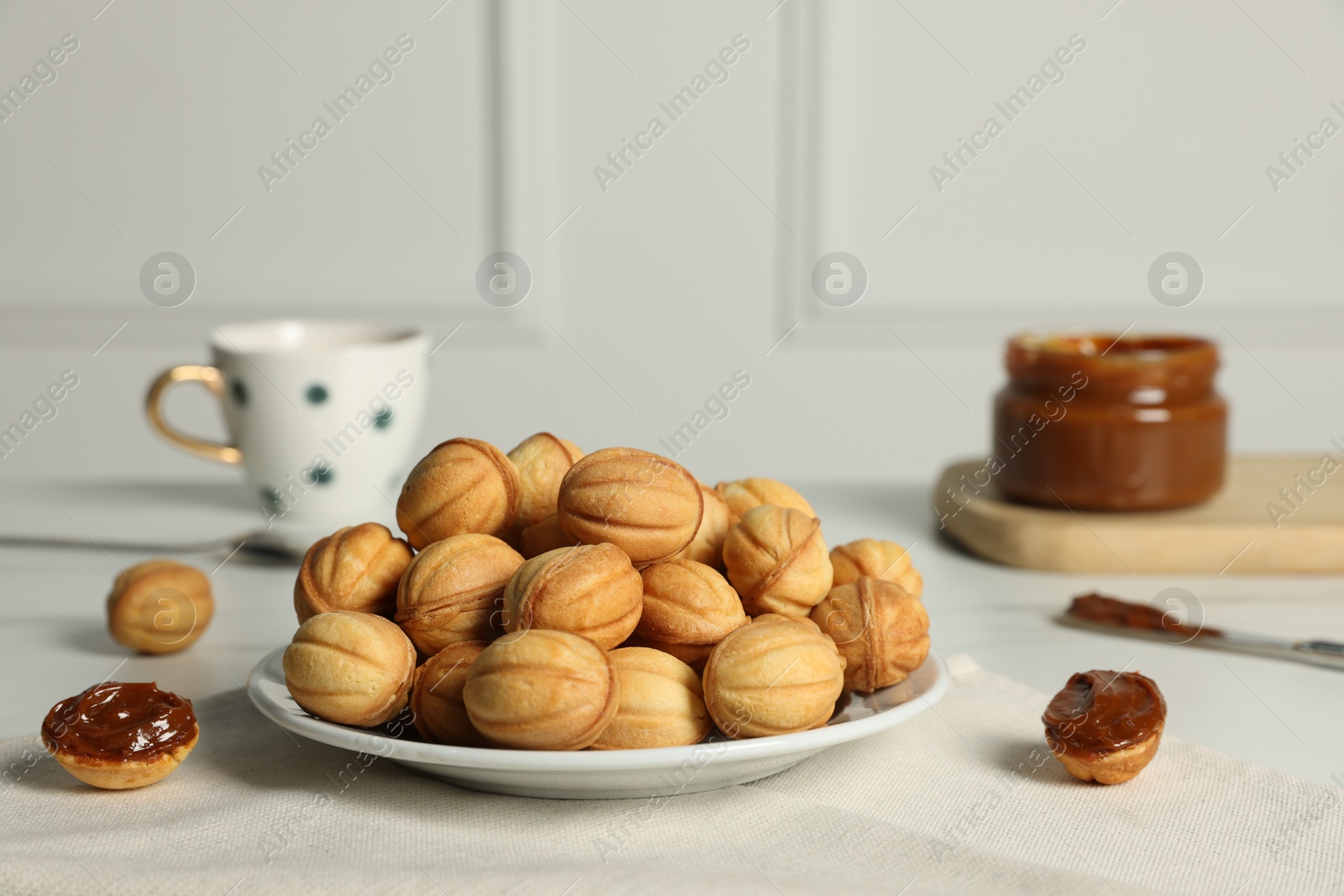Photo of Homemade walnut shaped cookies with boiled condensed milk on table