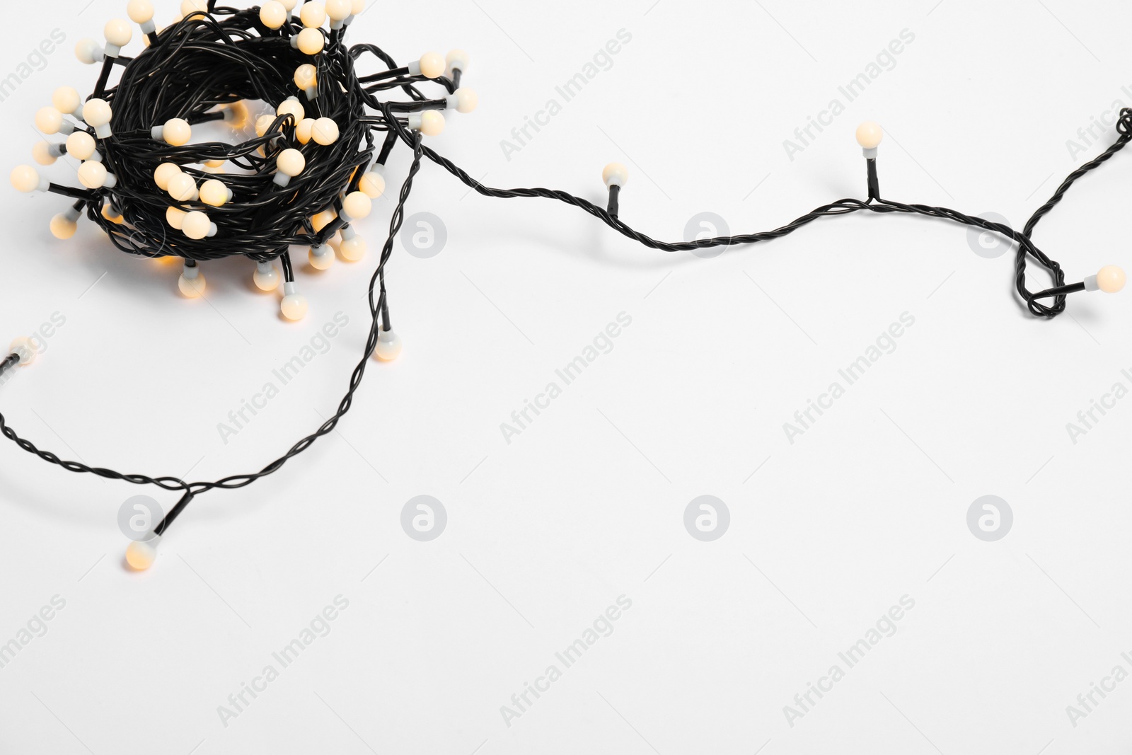 Photo of Beautiful Christmas lights on white background, top view