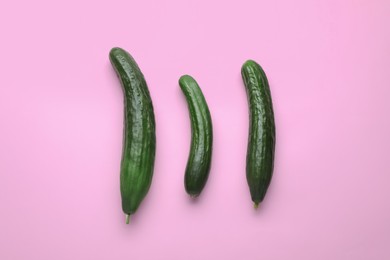 Photo of Fresh ripe cucumbers on pink background, flat lay
