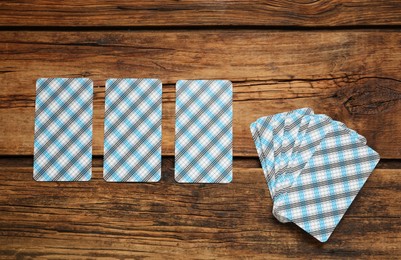 Photo of Tarot cards on wooden table, flat lay. Reverse side