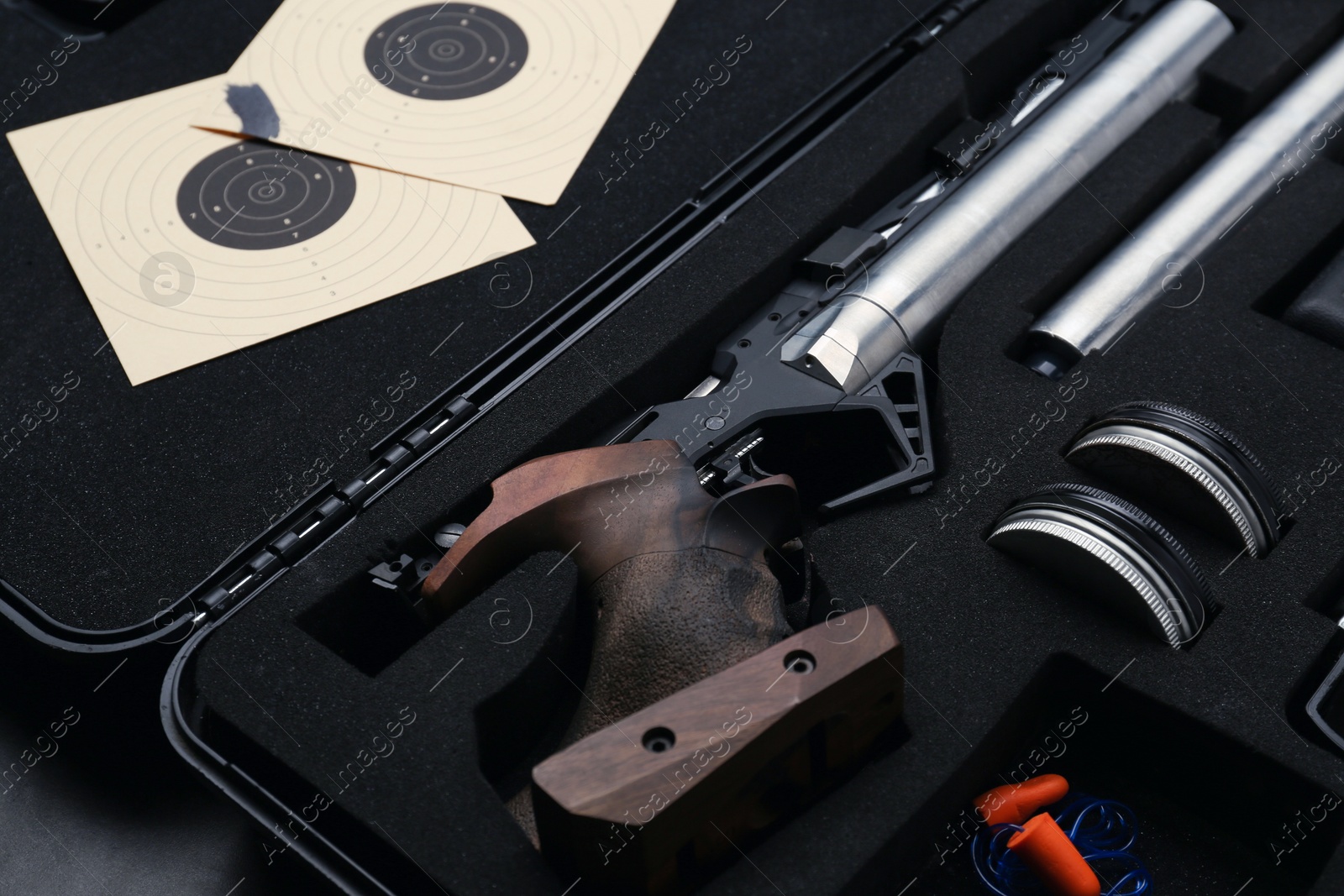 Photo of Case with sport pistol and accessories on black table, closeup. Professional gun