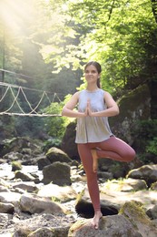 Photo of Happy young woman doing morning exercise in mountains