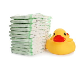 Photo of Stack of disposable diapers and toy duck on white background. Baby accessories