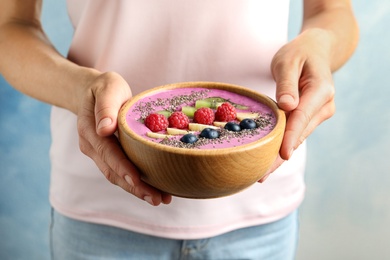 Photo of Woman holding bowl of acai smoothie with chia seeds, closeup