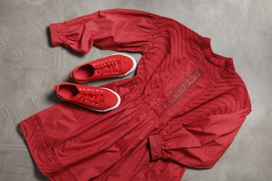 Stylish red dress and shoes on grey stone background, flat lay