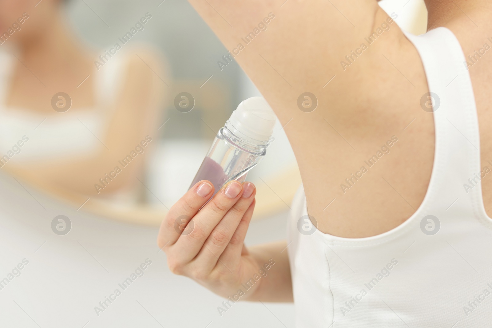 Photo of Beautiful woman applying deodorant in bathroom, closeup