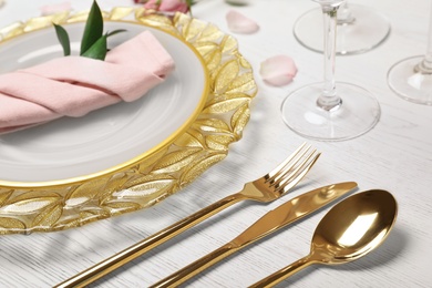 Festive table setting with plates, cutlery and napkin on wooden background, closeup