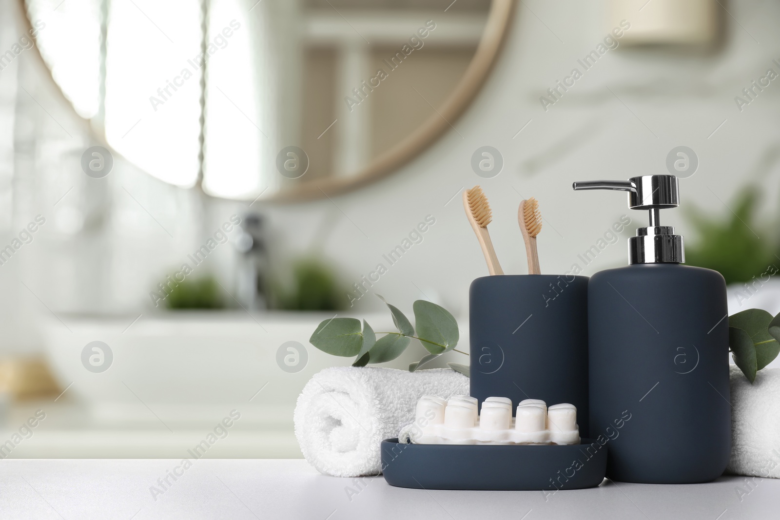 Image of Bath accessories. Different personal care products and eucalyptus leaves on white table in bathroom, space for text