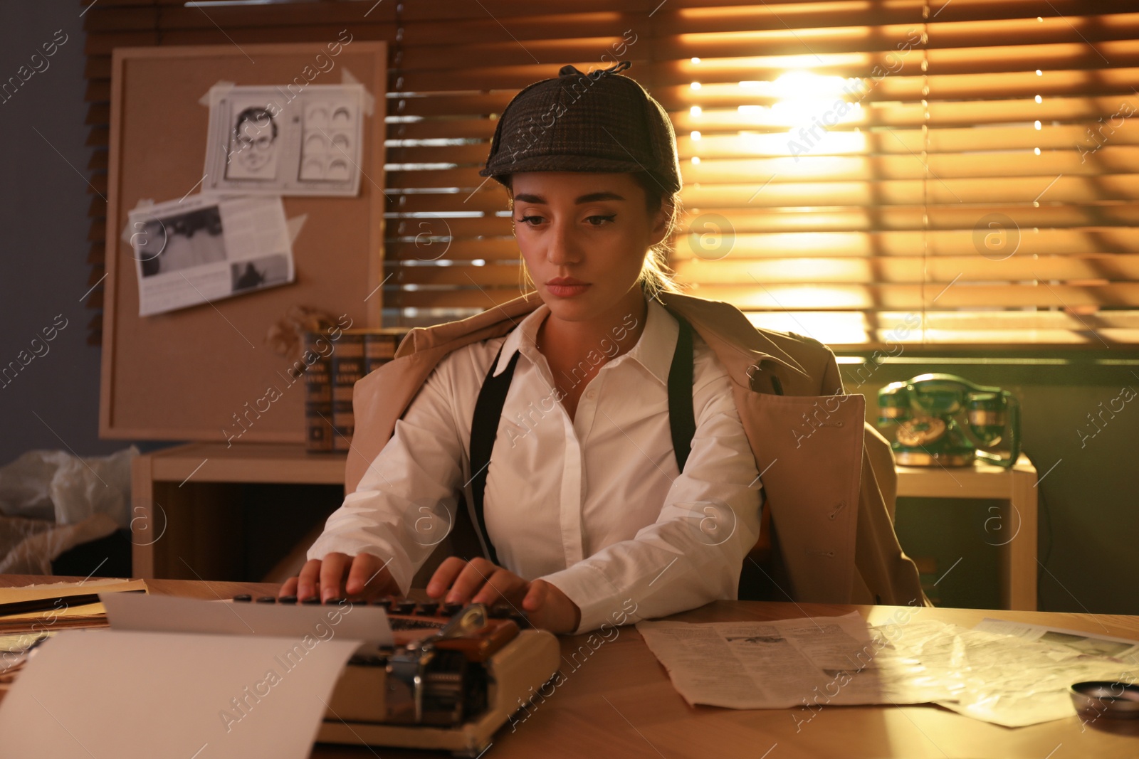 Photo of Old fashioned detective using typewriter at table in office