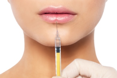 Photo of Young woman getting lips injection on white background, closeup. Cosmetic surgery