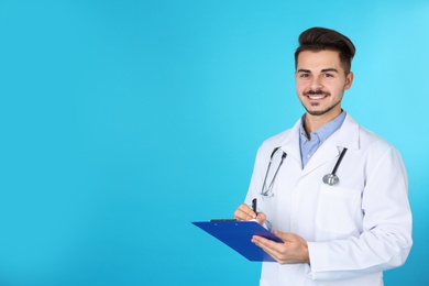 Photo of Young medical student with clipboard on color background. Space for text