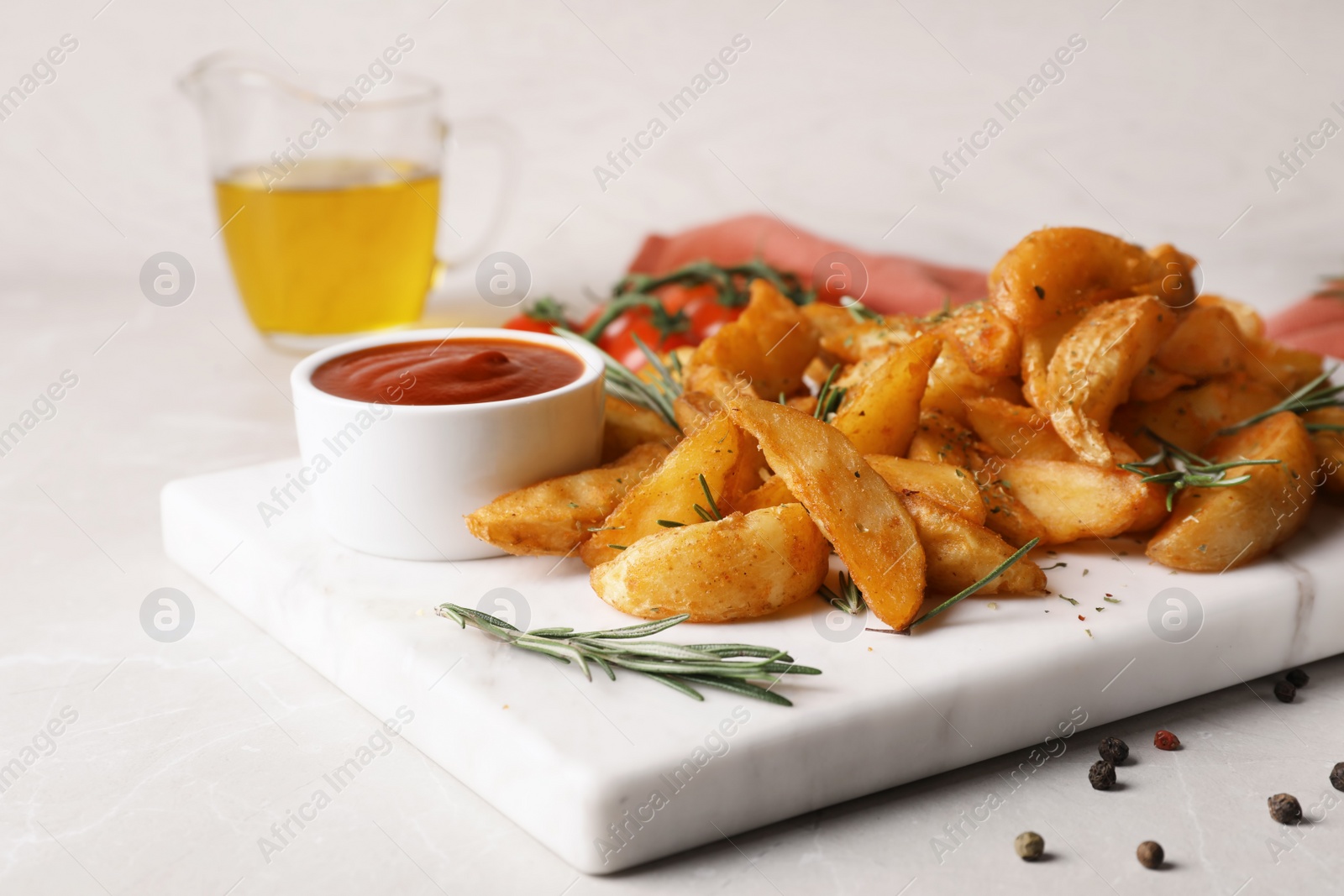 Photo of Baked potatoes served with rosemary and sauce on marble board