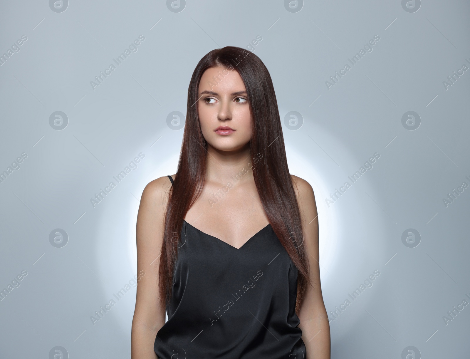 Photo of Beautiful young woman with healthy strong hair posing in studio