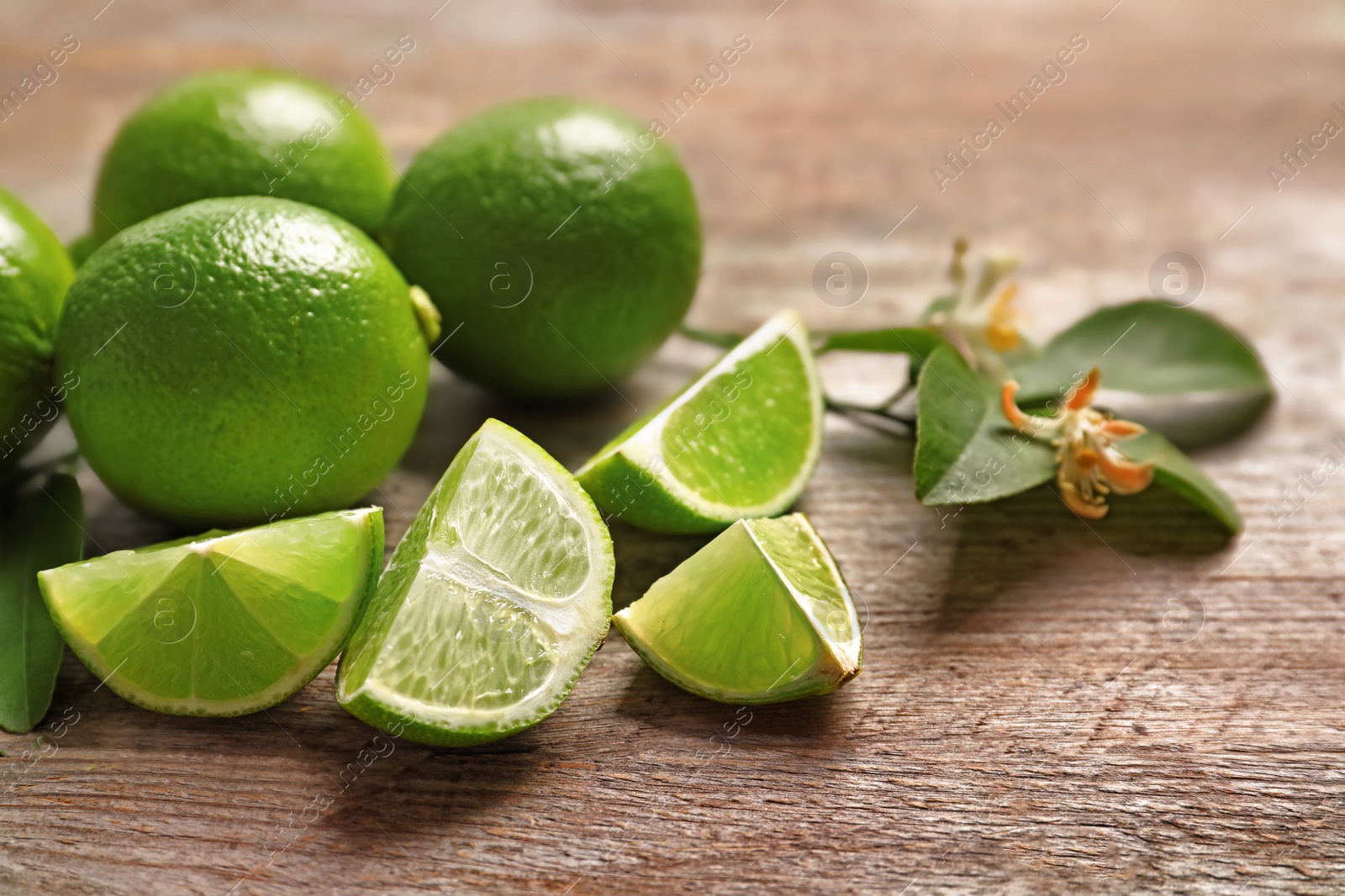 Photo of Fresh ripe limes on wooden table. Citrus fruit