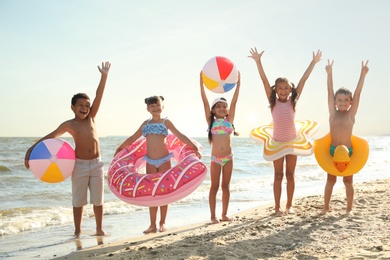 Cute children enjoying sunny day at beach. Summer camp