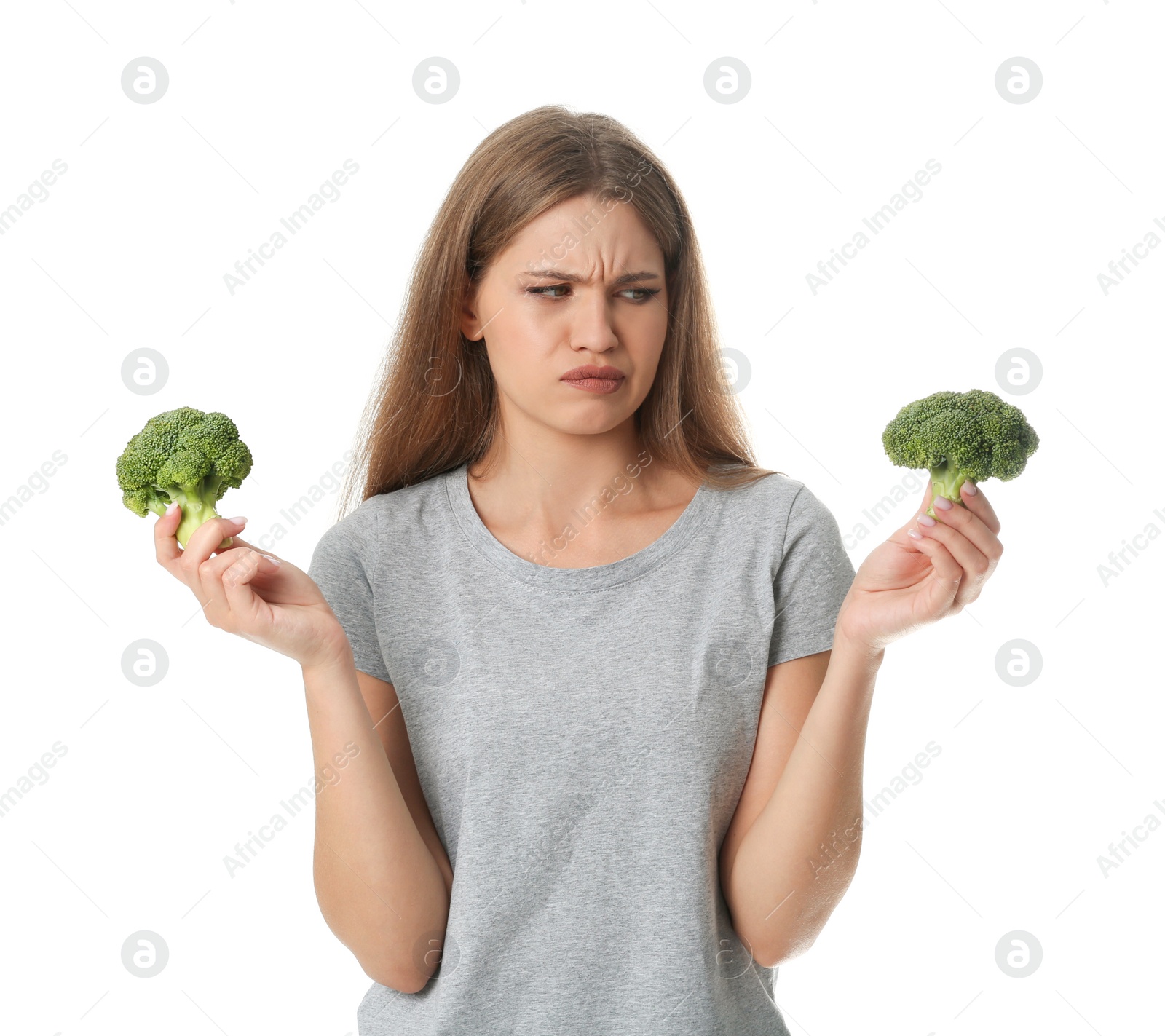 Photo of Portrait of unhappy woman with broccoli on white background