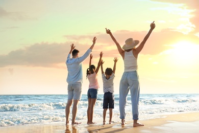 Photo of Family on sandy beach near sea. Summer vacation