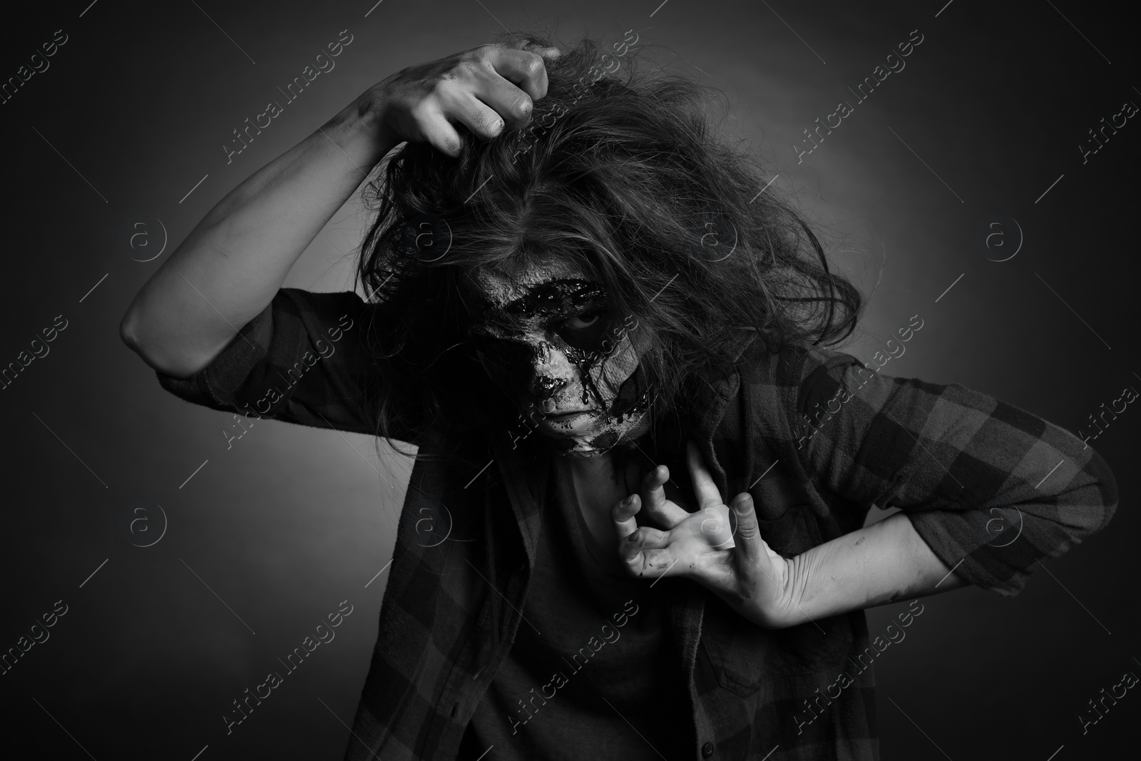 Photo of Scary zombie on dark background, black and white effect. Halloween monster