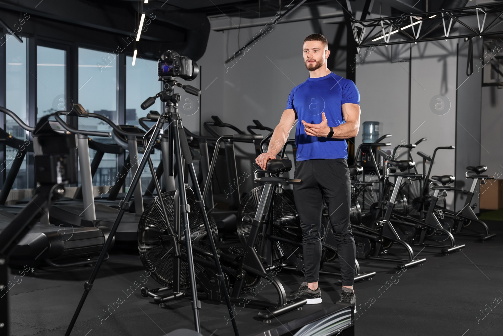 Photo of Man recording online training on camera at gym. Fitness coach