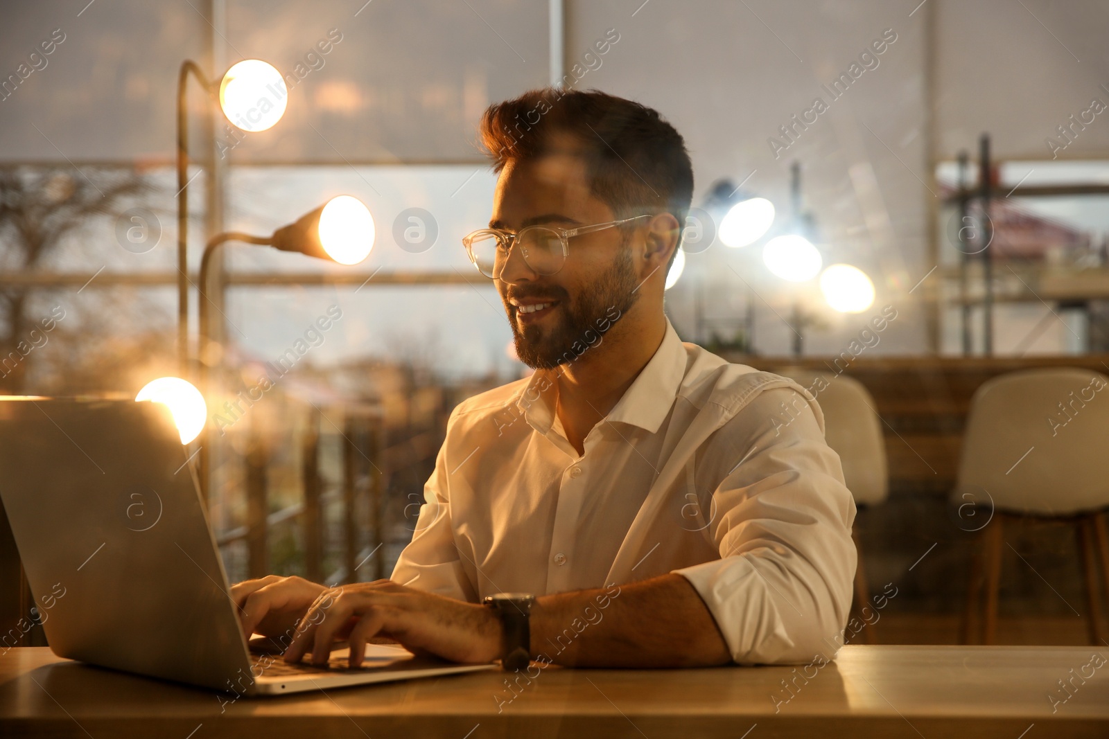 Photo of Man working with laptop at table in office