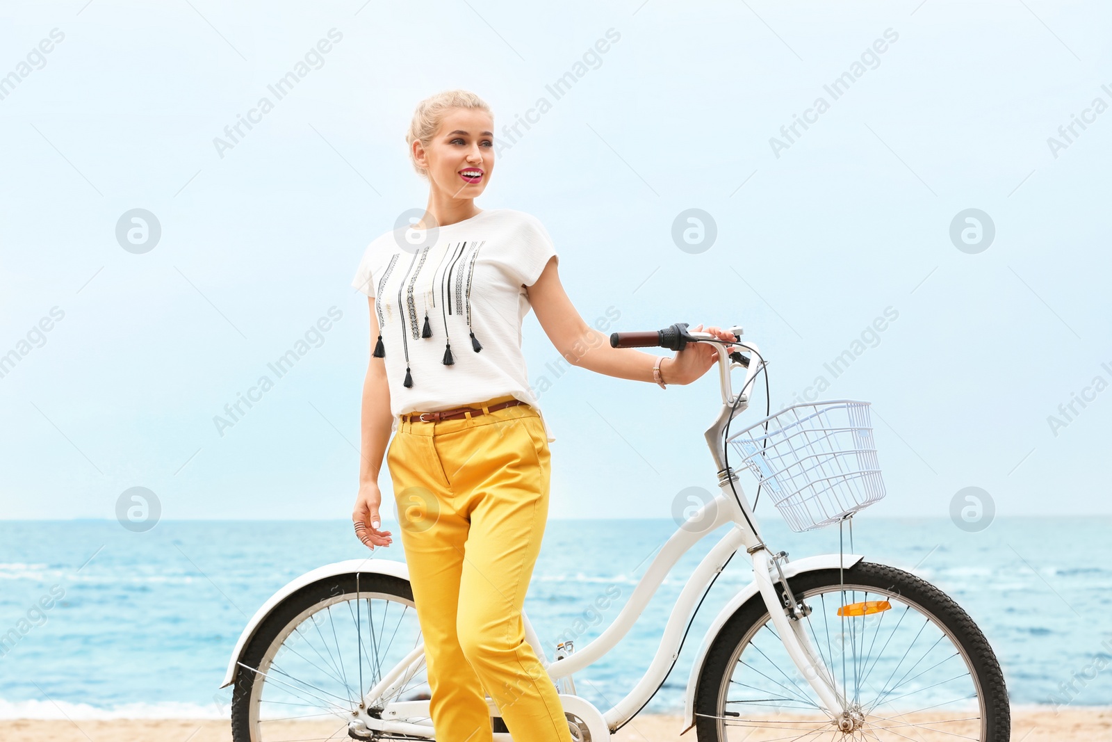 Photo of Beautiful woman in casual outfit with bicycle on sea coast