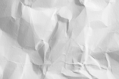 Photo of Crumpled white paper sheet as background, closeup