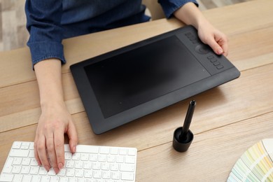 Photo of Professional designer working on graphic tablet at desk, closeup