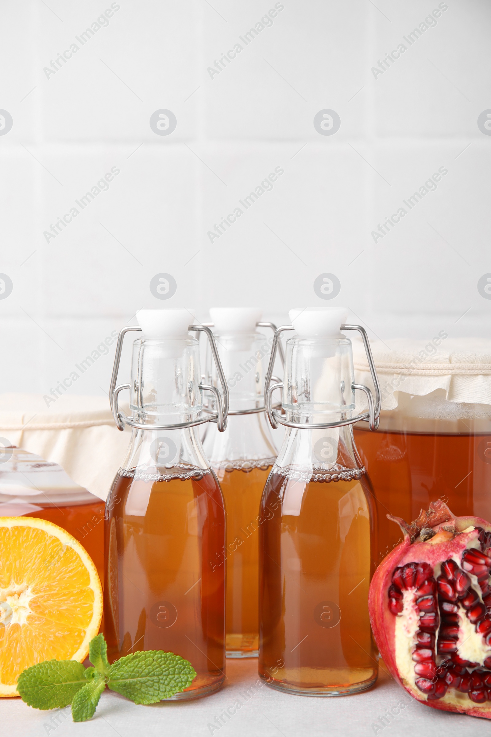 Photo of Tasty kombucha, fresh fruits and mint on white table