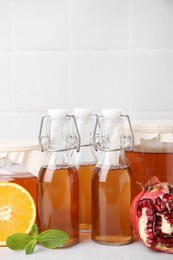 Photo of Tasty kombucha, fresh fruits and mint on white table