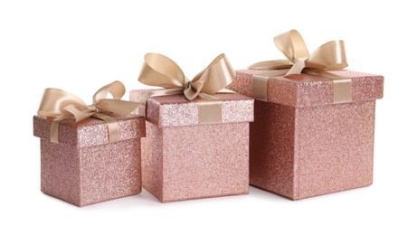 Photo of Shiny gift boxes with golden bows on white background