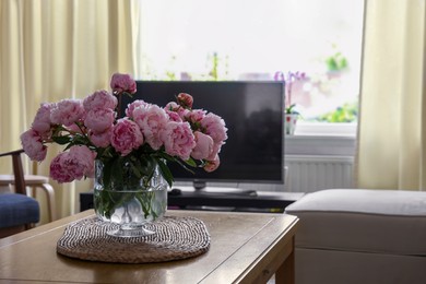 Beautiful pink peonies in vase on table at home, space for text. Interior design