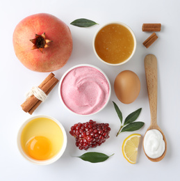 Photo of Composition with natural homemade mask, pomegranate and ingredients on white background, top view