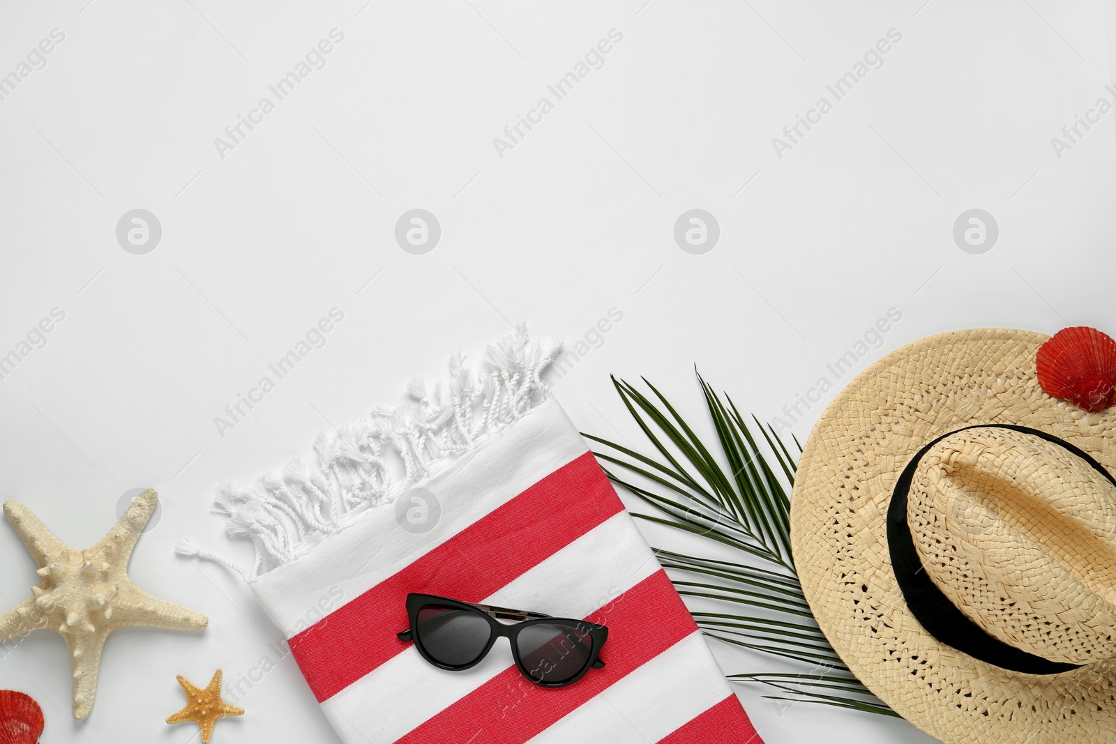 Photo of Beach towel, straw hat and sunglasses on light background, flat lay. Space for text