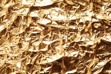 Photo of Crumpled gold foil as background, top view