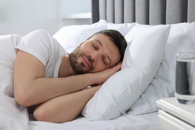 Photo of Handsome man sleeping in soft bed at home