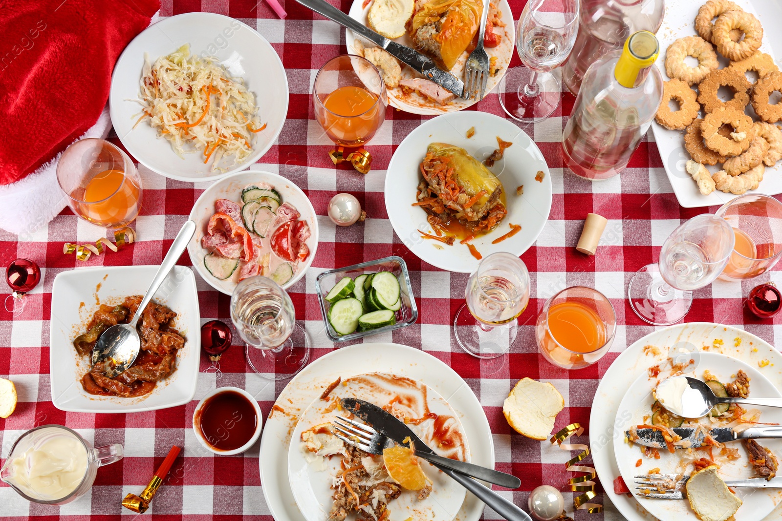 Photo of Flat lay composition of food leftovers after party on table with checkered cloth