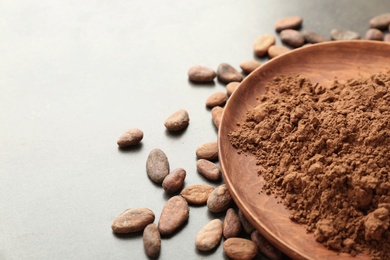 Composition with cocoa powder and beans on grey background