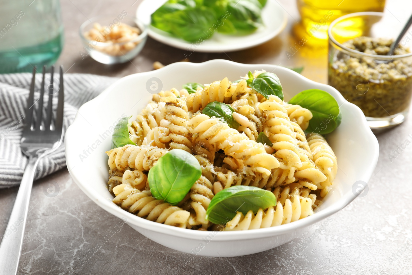 Photo of Plate of delicious basil pesto pasta served for dinner on table