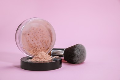 Photo of Loose face powder and brush on pink background, space for text