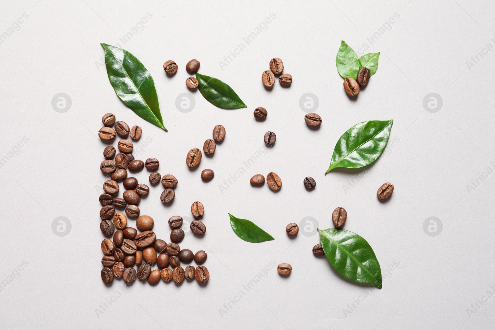 Photo of Fresh green coffee leaves and beans on light background, flat lay