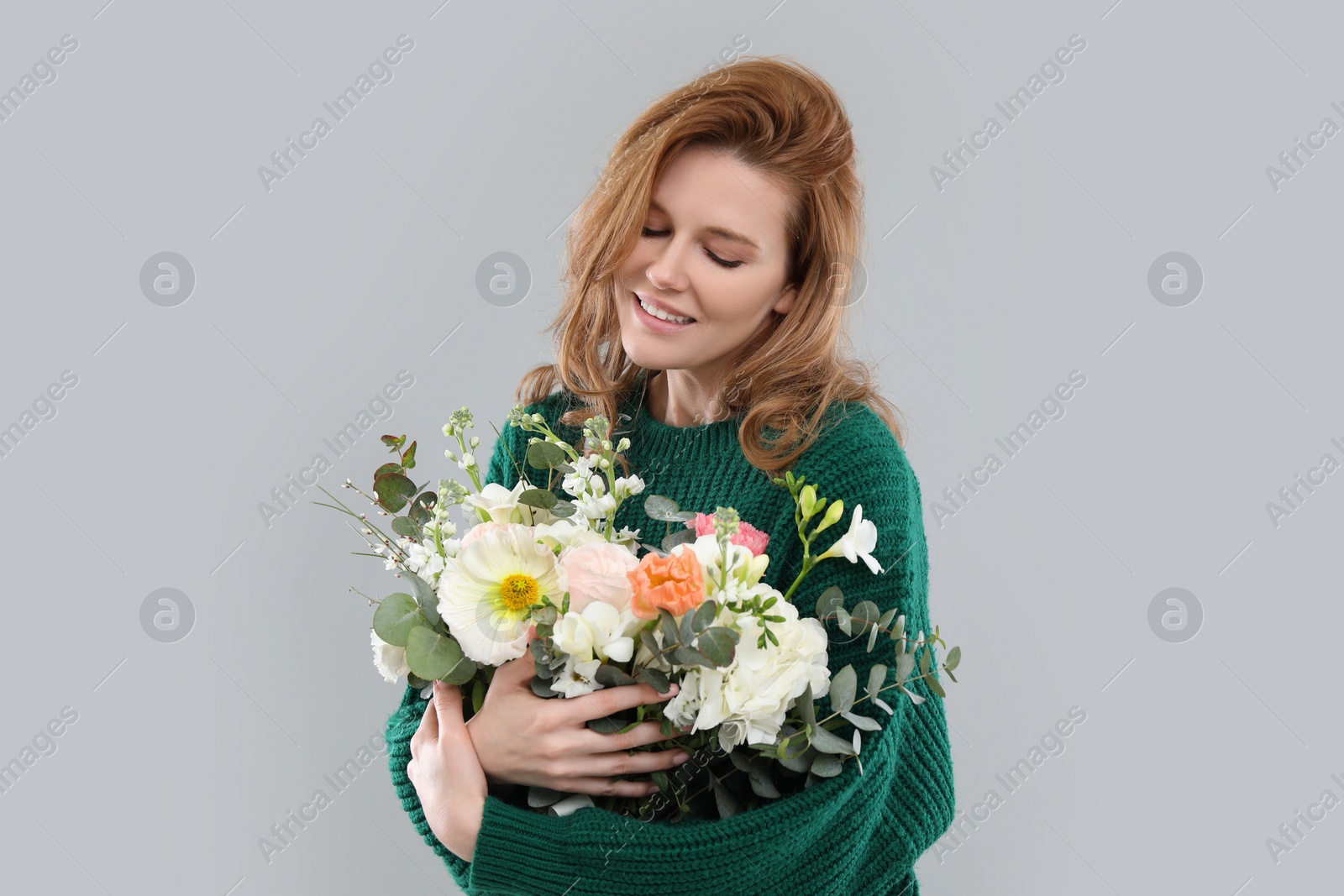 Photo of Beautiful woman with bouquet of flowers on grey background