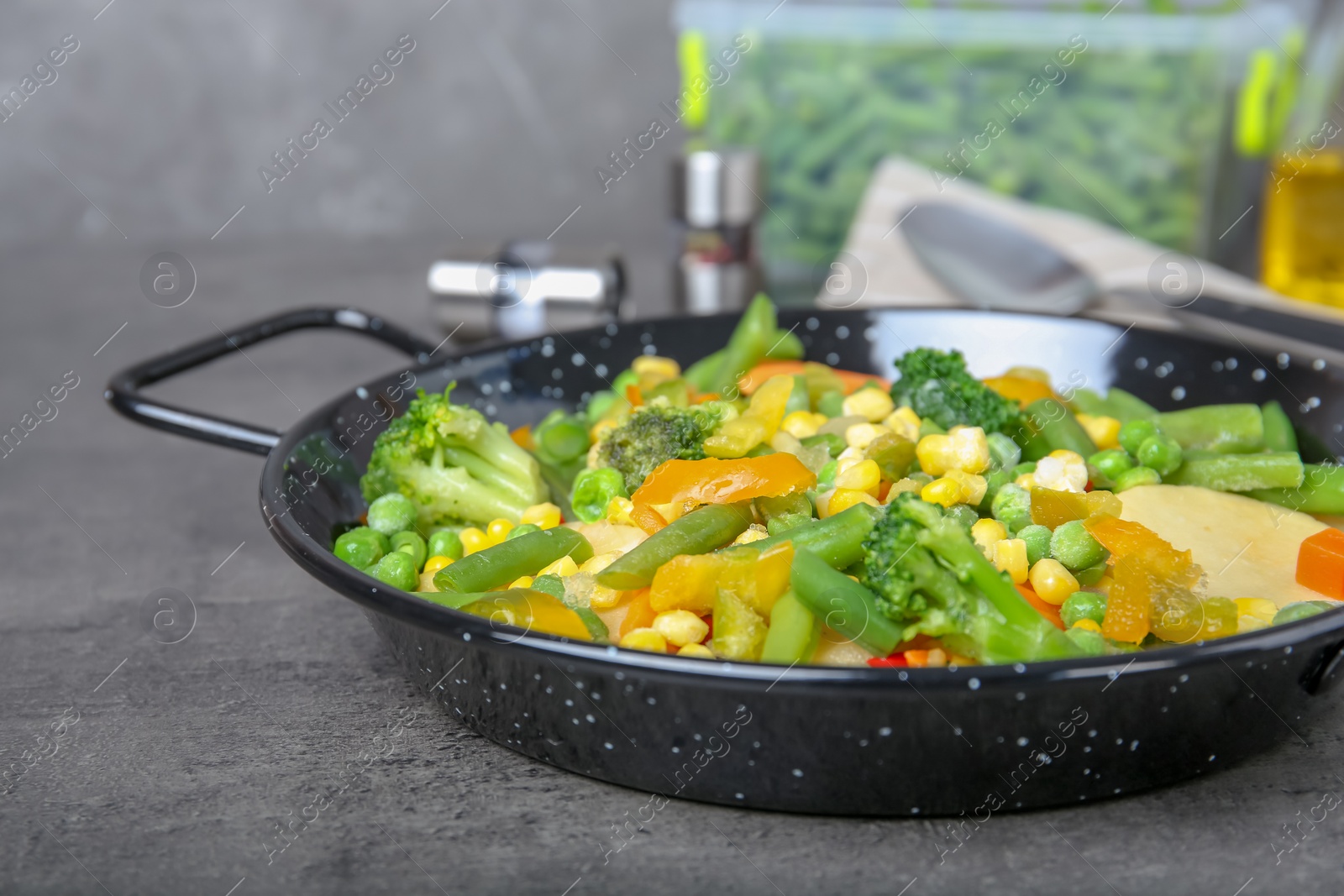 Photo of Frying pan with frozen vegetables on table, closeup