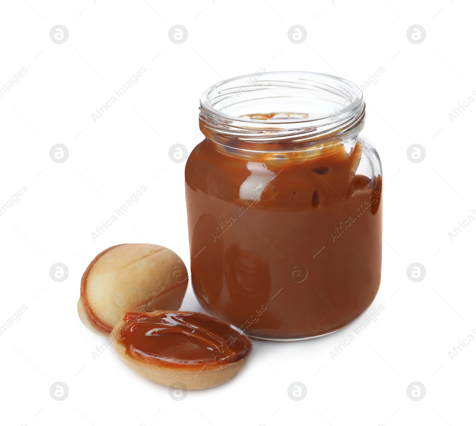 Photo of Jar with boiled condensed milk and walnut shaped cookies on white background