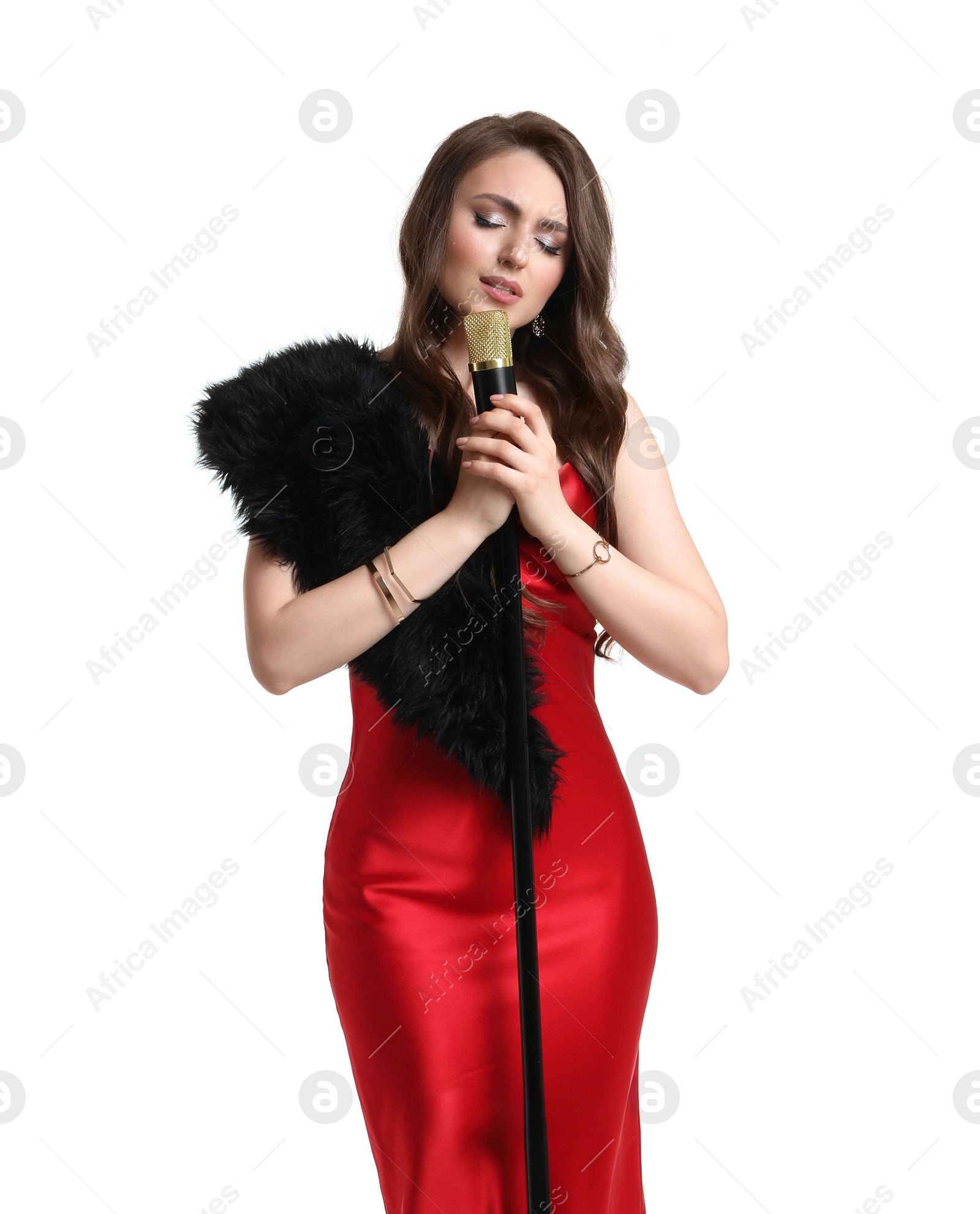 Photo of Beautiful young woman in stylish red dress with microphone singing on white background