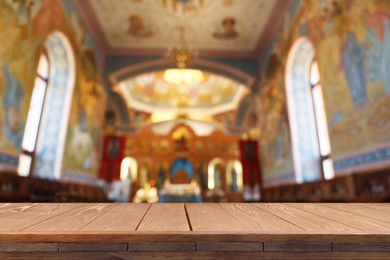 Image of Empty wooden table and blurred view of beautiful church interior, space for text